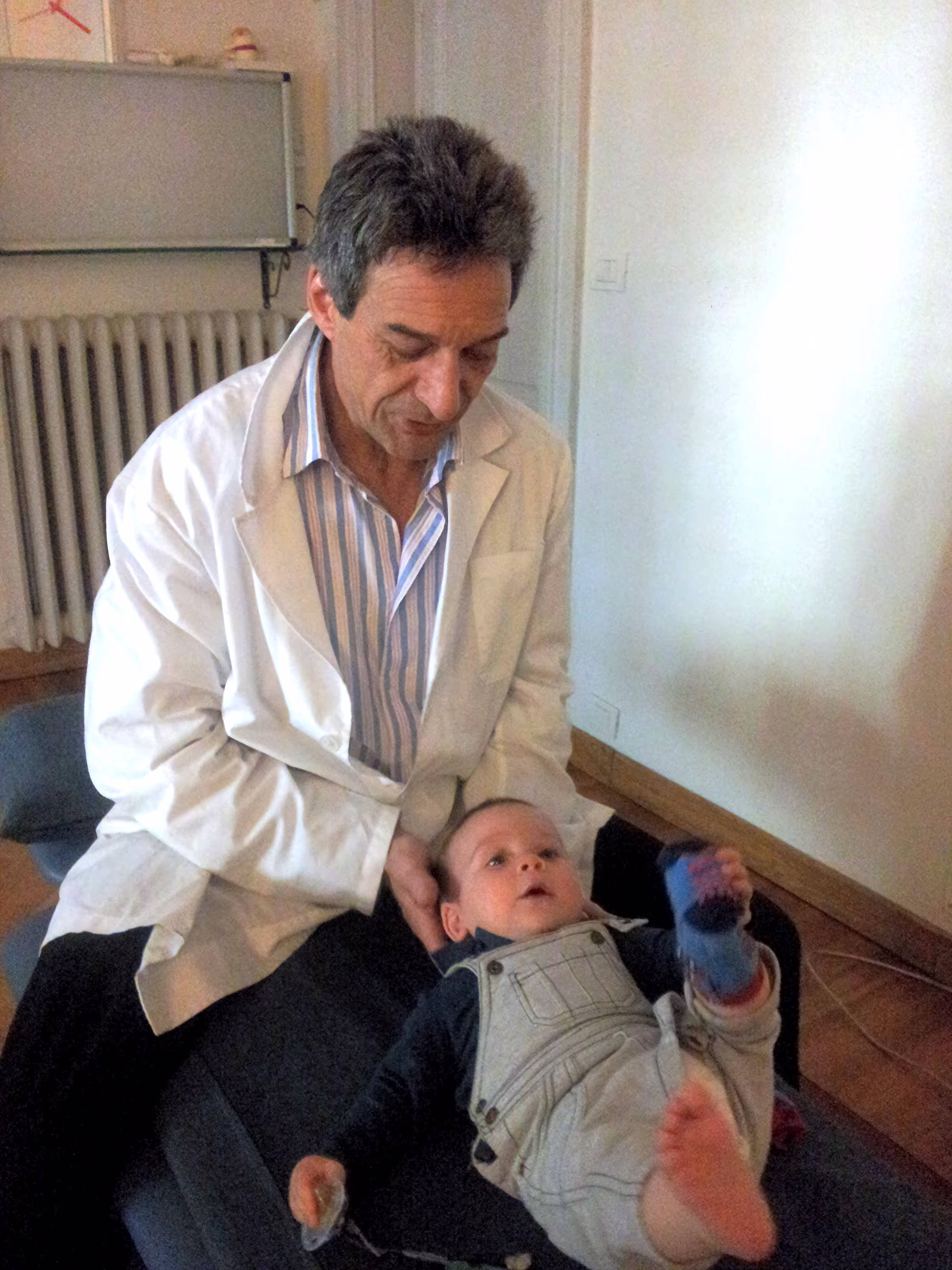Sandro Specchia visita un bambino applicando tecniche osteopatiche